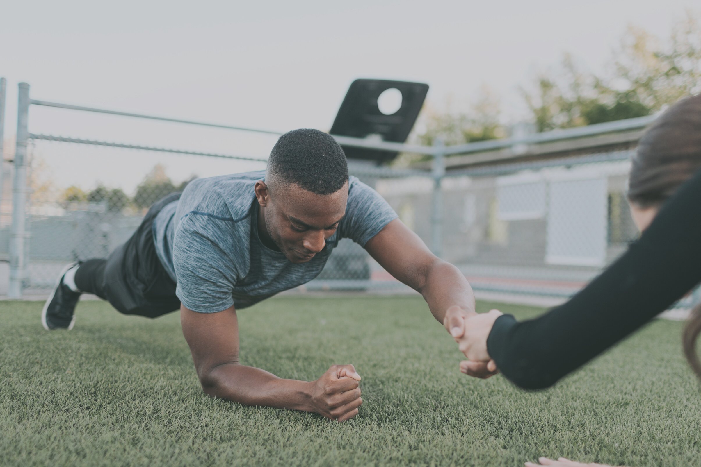 Man and Woman Planking While Holding Hands