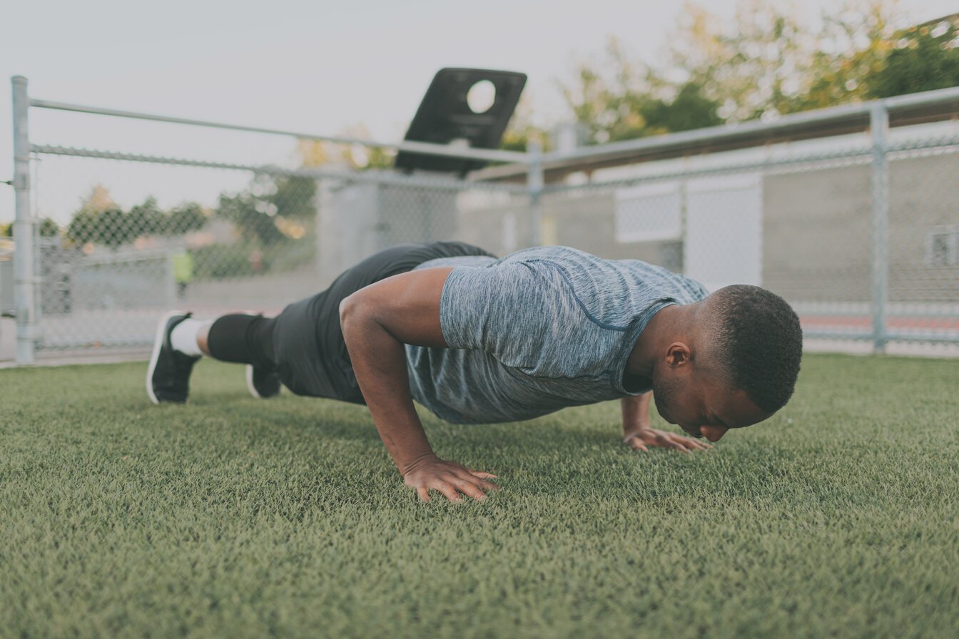 Athletic Man Doing Push Up in the Field